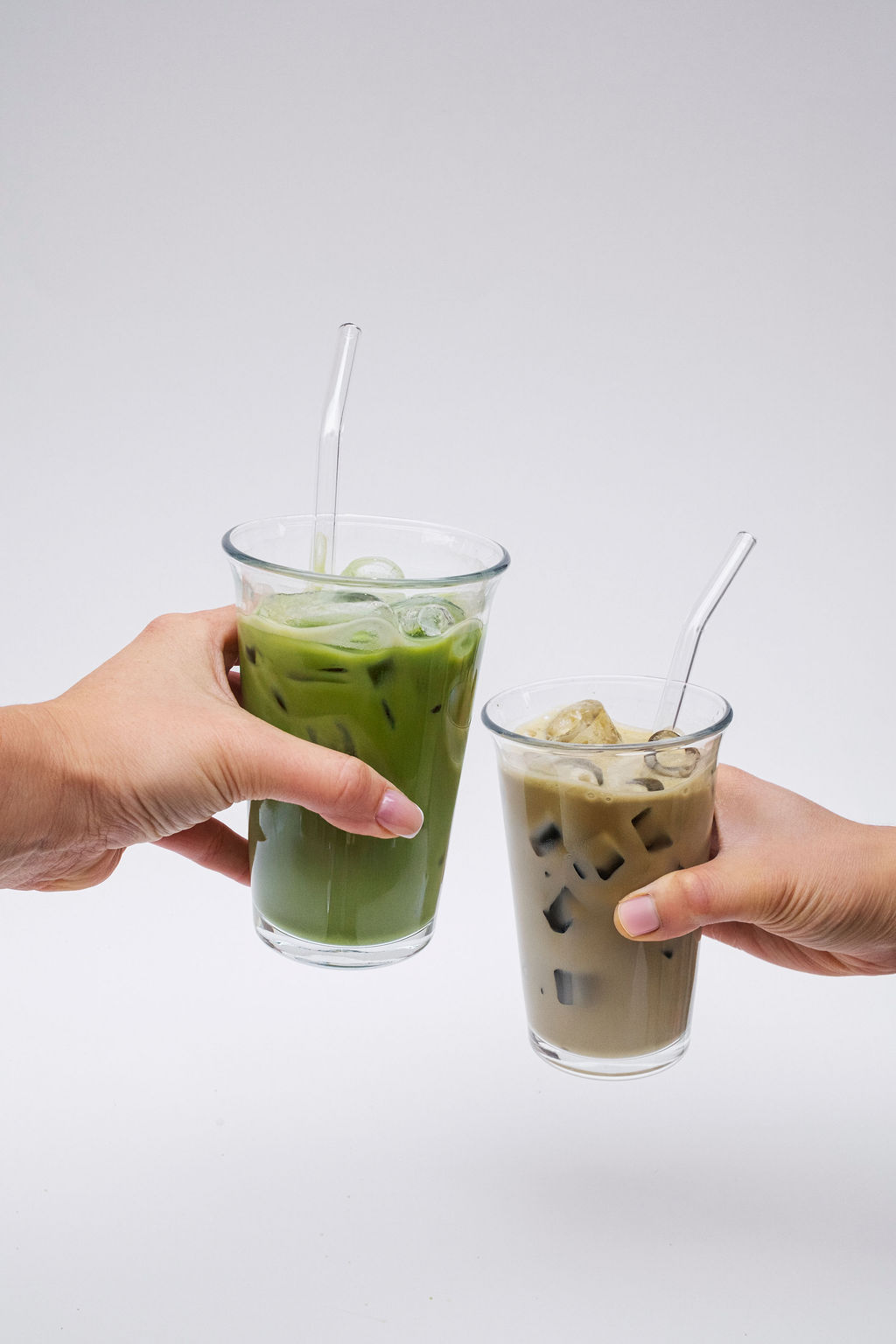 Tall elegant glass of iced matcha latte forming condensation in crisp bright sunlight